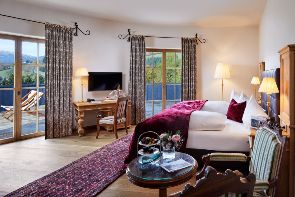 Großzügiges Hotelzimmer in Mittersill mit Boxspringbett, Terasse mit Panoramablick, Fernseher und gemütlicher Sitzecke