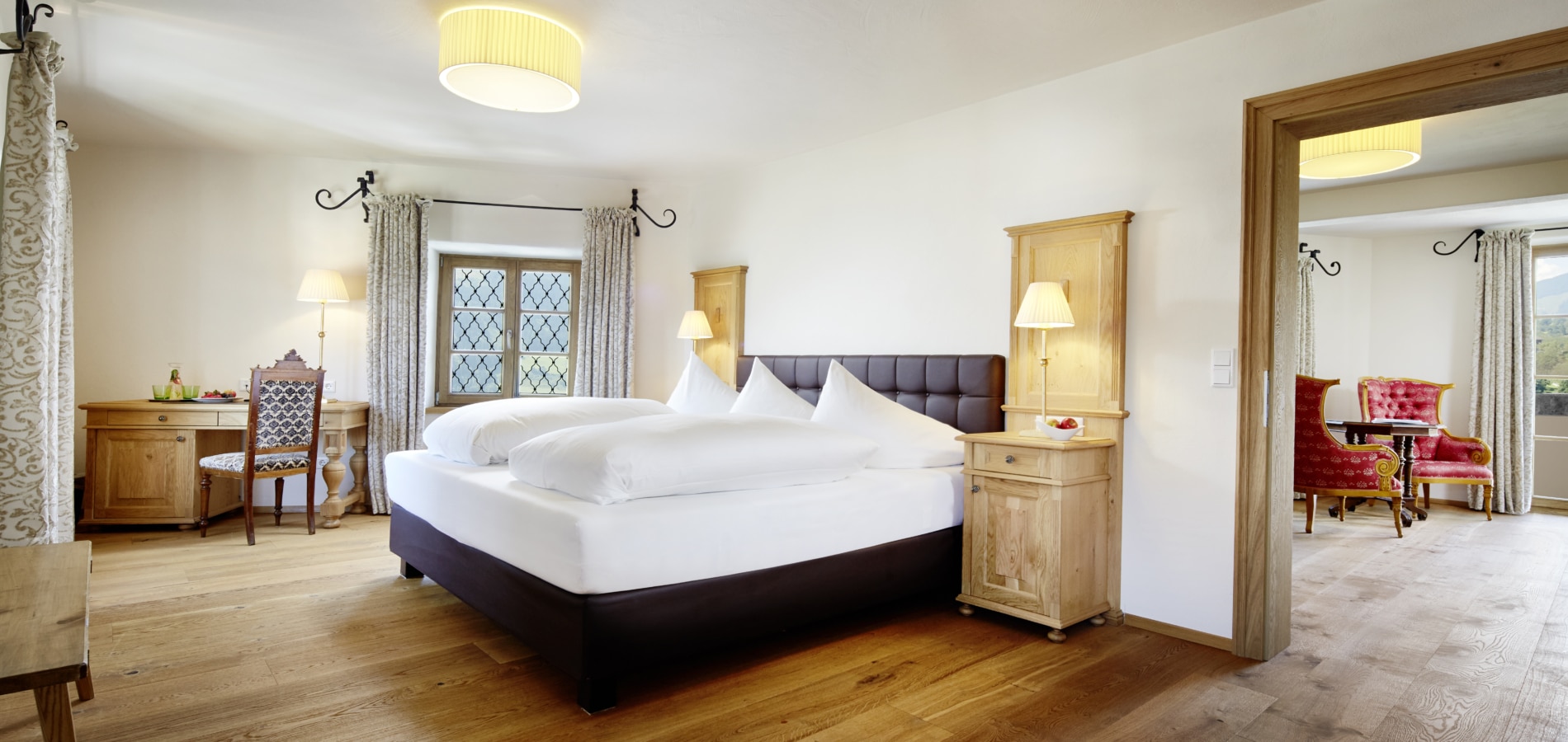 Interior view of the King Farouk Suite, with the bed in the foreground and a separate living area in the background