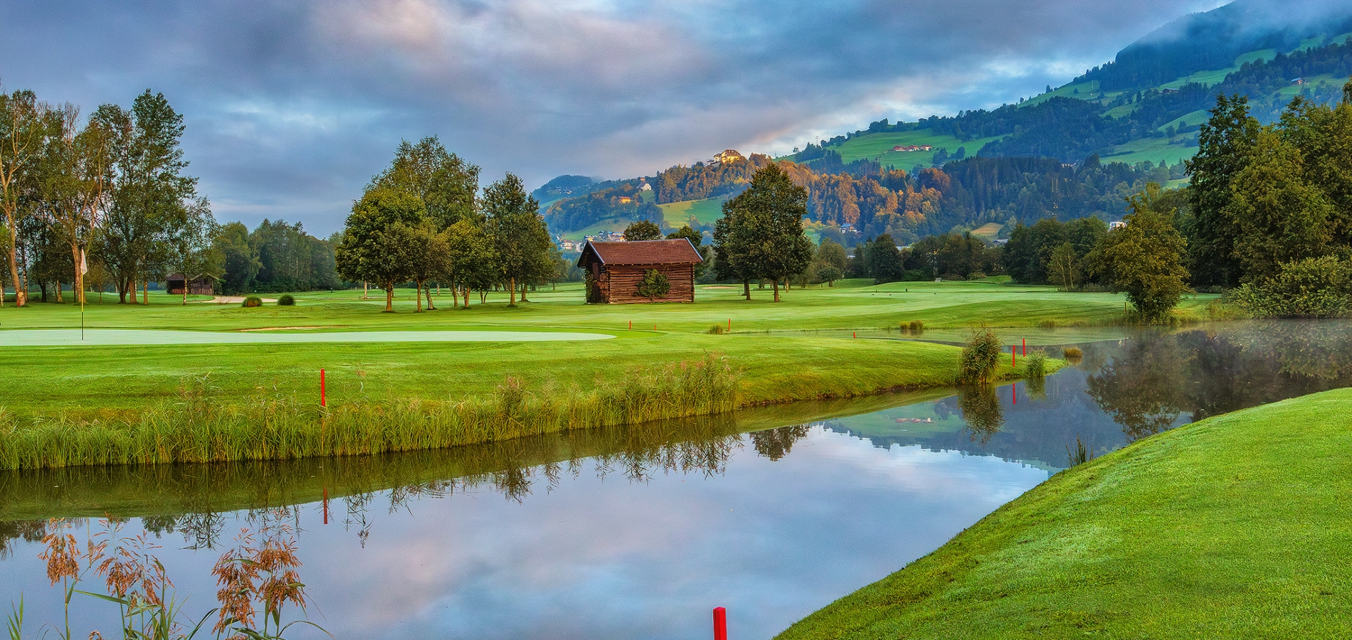 Wasserhindernis auf dem Golfplatz mit Spiegelung der umliegenden Landschaft