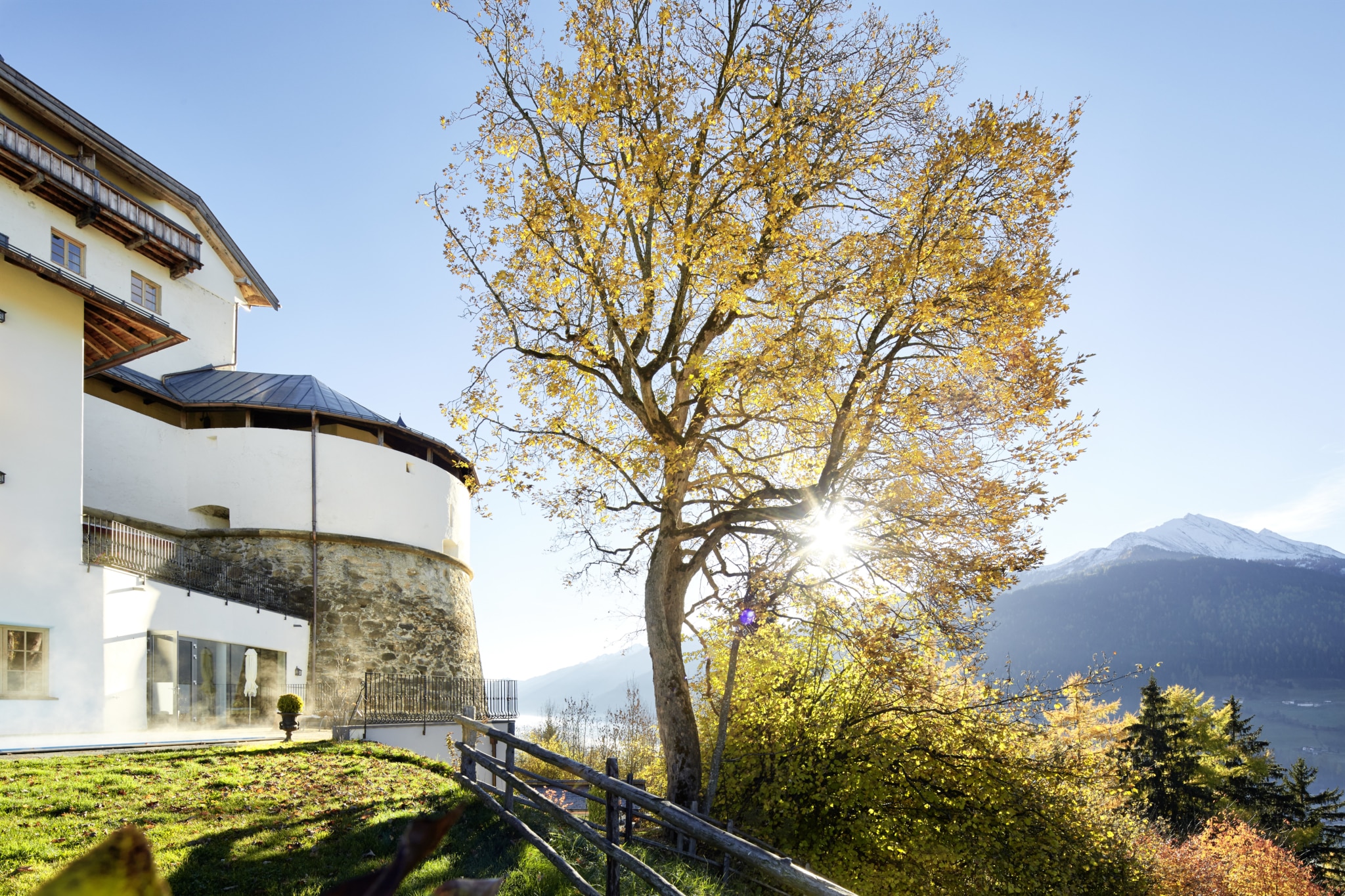 Panoramablick durch bunte Herbstblätter auf die Bergwelt der Hohen Tauern
