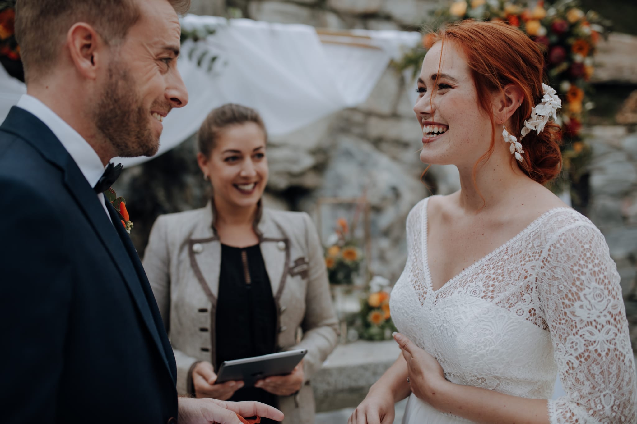 Brautpaar im Gespräch mit Traurednerin während einer Hochzeit im Hotel Schloss Mittersill